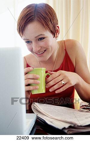 Stock Photo - Young woman working on laptop computer. Fotosearch