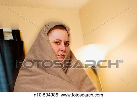 Young woman wrapped in a blanket View Large Photo Image Stock Photography - Young woman wrapped in a blanket. Fotosearch