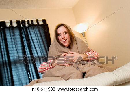 Young woman wrapped in a blanket with a young man's arms tightly holding her View Large Photo Image Stock Photo - Young woman wrapped in a blanket with a young man's arms tightly holding her. Fotosearch