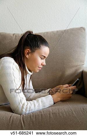 Young woman writting sms in her cellular phone View Large Photo Image Stock Image - Young woman writting sms in her cellular phone. Fotosearch