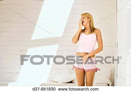 Young woman yawning at home View Large Photo Image Stock Image - Young woman yawning at home. Fotosearch