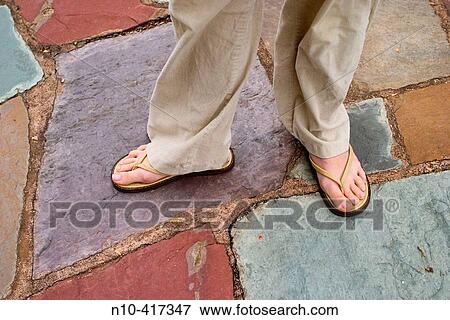 Young woman's feet in sandals, which are standing on a stone floor. View Large Photo Image Stock Photo - Young woman's feet in sandals, which are standing on a stone floor.. Fotosearch