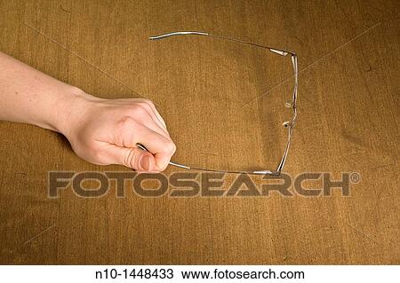 Young woman's hand holding her glasses View Large Photo Image Stock Image - Young woman's hand holding her glasses. Fotosearch