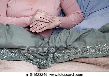 Young woman's hands as she sits in her bed View Large Photo Image Stock Photograph - Young woman's hands as she sits in her bed. Fotosearch