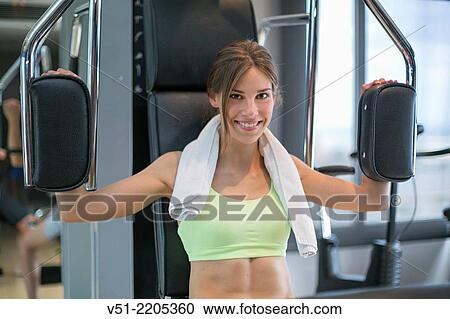 Young womant using a bench press in a fitness center and smiling at camera View Large Photo Image Stock Image - Young womant using a bench press in a fitness center and smiling at camera. Fotosearch