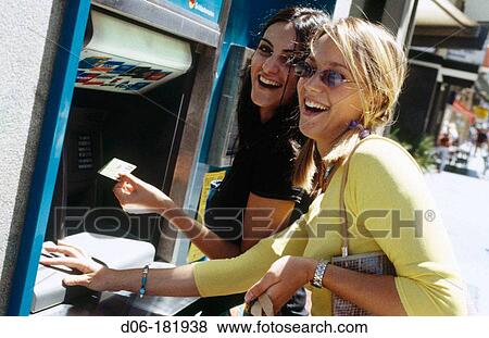 Young women at cash dispenser View Large Photo Image Stock Photo - Young women at cash dispenser. Fotosearch