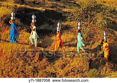 Stock Photo - Young women Carrying water from the local well, Maharashtra, India. Fotosearch