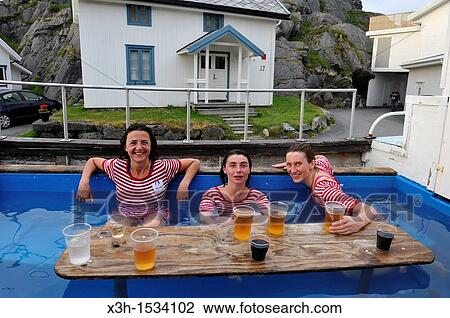 young women drinking beer and bathing in an outdoor hot tub settled in a boat, dressed with old-fashioned swimming costumes, Hamn i Senja, Senja island, County of Troms, Norway, Northern Europe View Large Photo Image Stock Image - young women drinking beer and bathing in an outdoor hot tub settled in a boat, dressed with old-fashioned swimming costumes, Hamn i Senja, Senja island, County of Troms, Norway, Northern Europe. Fotosearch