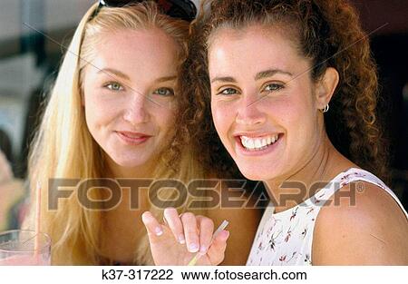 Stock Image - Young women, drinking fruit juices. Fotosearch