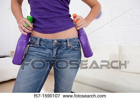Stock Photo - Young women holding detergents on her hips. Fotosearch