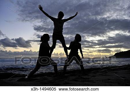 Stock Photography - young women in balance on the beach of Grand Anse Saint-Joseph Reunion island, overseas departement of France, Indian Ocean. Fotosearch