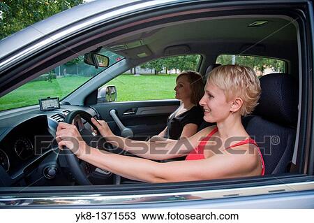 Stock Image - Young women on driving on road trip. Fotosearch