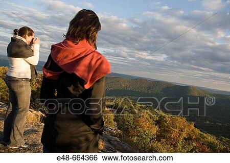 Young women outside taking photograph of Bear Mountain, New York State, USA View Large Photo Image Stock Photograph - Young women outside taking photograph of Bear Mountain, New York State, USA. Fotosearch