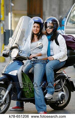 Stock Photograph - Young women riding a vespa, Palermo, Sicily, Italy.. Fotosearch