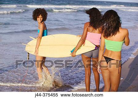 Young women with surfboard at the beach View Large Photo Image Stock Photography - Young women with surfboard at the beach. Fotosearch