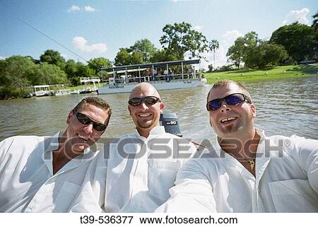 Zambezi River, Zimbabwe. 3 men looking at the camera on a boat wearing white shirts smiling View Large Photo Image Stock Photo - Zambezi River, Zimbabwe. 3 men looking at the camera on a boat wearing white shirts smiling. Fotosearch