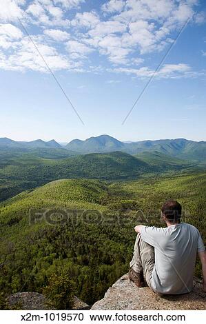 Stock Image - Zealand Notch - A hiker takes in the views from the summit of Zeacliff during the summer months Located along the Appalachian Trail in the White Mountains, New Hampshire USA. Fotosearch