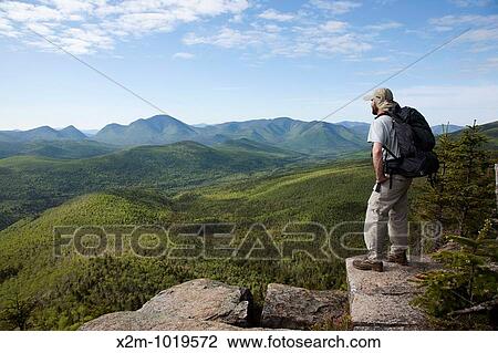 Stock Image - Zealand Notch - A hiker takes in the views from the summit of Zeacliff during the summer months Located along the Appalachian Trail in the White Mountains, New Hampshire USA. Fotosearch