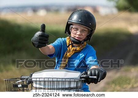 Picture - A boy of eleven years on a scooter.. Fotosearch