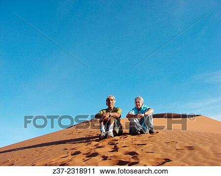A couple sitting on a sand dune in Sossusvlei desert, Namibia View Large Photo Image Stock Image - A couple sitting on a sand dune in Sossusvlei desert, Namibia. Fotosearch