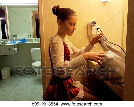 An eleven year old girl prepares her make up and hair in hotel room for a figure skating competition. View Large Photo Image Picture - An eleven year old girl prepares her make up and hair in hotel room for a figure skating competition.. Fotosearch