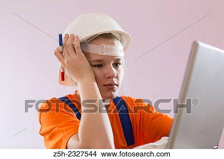 Picture - Beautiful girl-builder with a computer.. Fotosearch