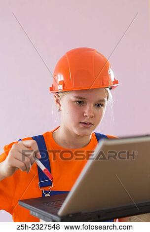 Stock Photo - Beautiful girl-builder with a computer.. Fotosearch