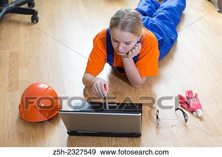 Stock Photo - Beautiful girl-builder with a computer.. Fotosearch