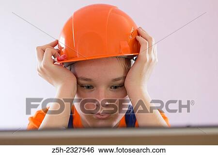Stock Photograph - Beautiful girl-builder with a computer.. Fotosearch