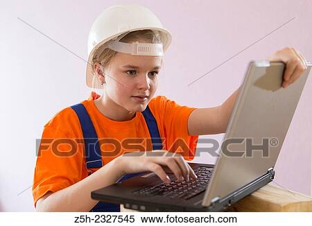 Stock Photography - Beautiful girl-builder with a computer.. Fotosearch