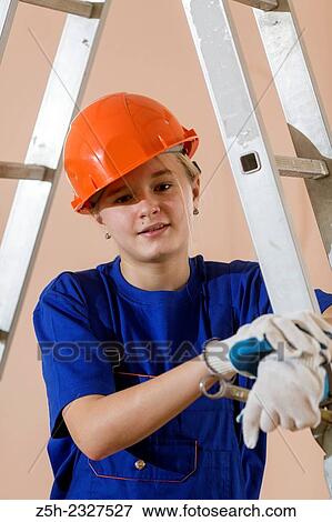 Stock Photo - Beautiful girl-builder with a ladder.. Fotosearch