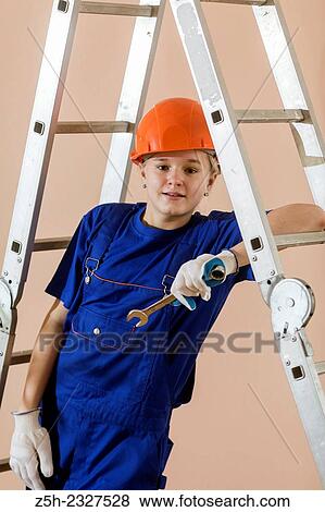 Stock Photo - Beautiful girl-builder with a ladder.. Fotosearch