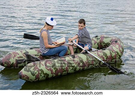 Boy and girl of twelve years in a rubber boat on the river going. View Large Photo Image Picture - Boy and girl of twelve years in a rubber boat on the river going.. Fotosearch