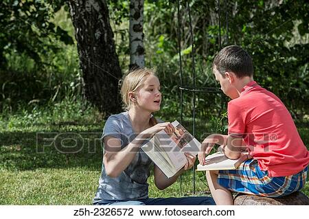 Boy and girl twelve years reading books on nature. View Large Photo Image Stock Image - Boy and girl twelve years reading books on nature.. Fotosearch