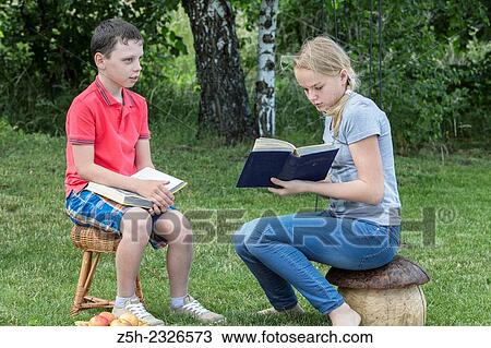 Boy and girl twelve years reading books on nature. View Large Photo Image Stock Image - Boy and girl twelve years reading books on nature.. Fotosearch