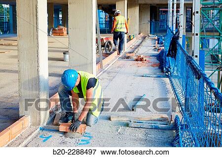 Stock Photo - Bricklayers placing half round. Homebuilding. Donostia, San Sebastian, Basque Country, Spain.. Fotosearch