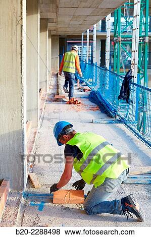 Stock Photo - Bricklayers placing half round. Homebuilding. Donostia, San Sebastian, Basque Country, Spain.. Fotosearch
