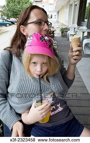 Chilly daughter wrapped inside mom's sweater sipping her orange juice thru a straw age 6 and 34. Rawa Mazowiecka Central Poland. View Large Photo Image Stock Photo - Chilly daughter wrapped inside mom's sweater sipping her orange juice thru a straw age 6 and 34. Rawa Mazowiecka Central Poland.. Fotosearch