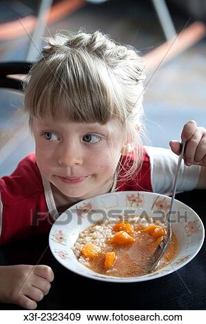 Cute young girl age 5 enjoying a traditional Polish tomato soup with carrots. Zupa pomidorowa. Zawady Central Poland. View Large Photo Image Stock Photo - Cute young girl age 5 enjoying a traditional Polish tomato soup with carrots. Zupa pomidorowa. Zawady Central Poland.. Fotosearch