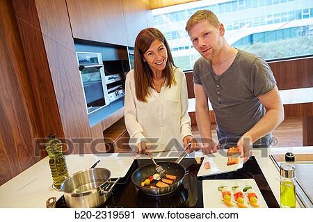 Stock Image - Family in the kitchen. Couple. Healthy eating. Healthy growth. Cooking fish and vegetable skewer.. Fotosearch