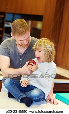 Family in the kitchen. Father and son. Healthy eating. Healthy growth. Apple. View Large Photo Image Stock Image - Family in the kitchen. Father and son. Healthy eating. Healthy growth. Apple.. Fotosearch