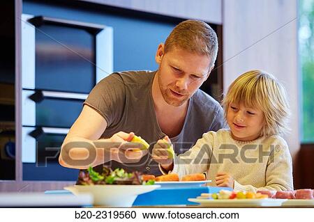 Family in the kitchen. Father and son. Healthy eating. Healthy growth. Taking lemon fish. View Large Photo Image Stock Image - Family in the kitchen. Father and son. Healthy eating. Healthy growth. Taking lemon fish.. Fotosearch