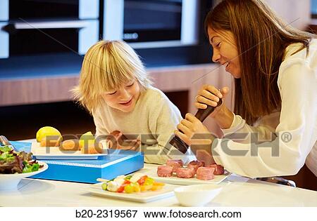 Family in the kitchen. Mother and son. Healthy eating. Healthy growth. Season the fish. View Large Photo Image Stock Photo - Family in the kitchen. Mother and son. Healthy eating. Healthy growth. Season the fish.. Fotosearch