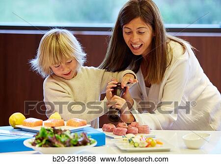 Family in the kitchen. Mother and son. Healthy eating. Healthy growth. Season the fish. View Large Photo Image Stock Photo - Family in the kitchen. Mother and son. Healthy eating. Healthy growth. Season the fish.. Fotosearch