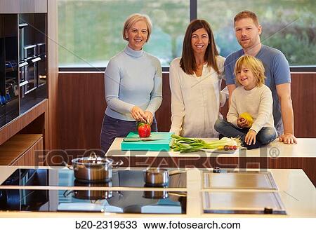 Stock Image - Family in the kitchen. Three generations. Healthy eating. Healthy growth. Vegetables.. Fotosearch