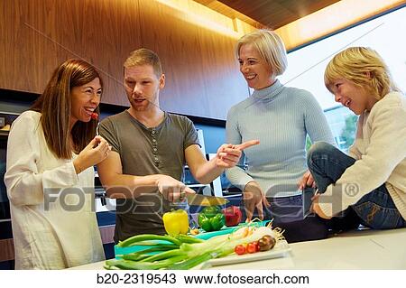 Stock Image - Family in the kitchen. Three generations. Healthy eating. Healthy growth. Vegetables.. Fotosearch