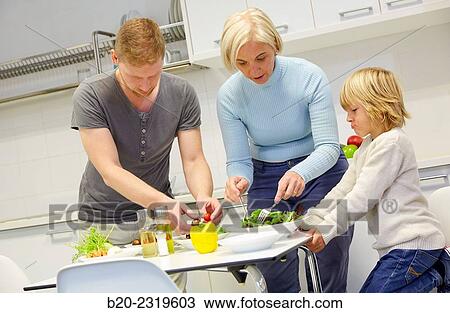 Stock Image - Family in the kitchen. Three generations. Healthy eating. Healthy growth. Making vegetable salad.. Fotosearch