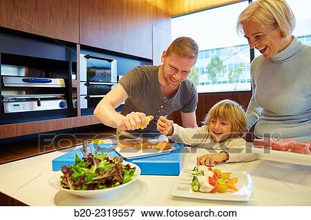 Family in the kitchen. Three generations. Healthy eating. Healthy growth. Taking lemon fish. View Large Photo Image Stock Photo - Family in the kitchen. Three generations. Healthy eating. Healthy growth. Taking lemon fish.. Fotosearch