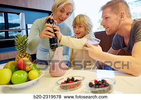 Family in the kitchen. Three generations. Healthy eating. Healthy growth. Making milkshakes with berries. View Large Photo Image Stock Photo - Family in the kitchen. Three generations. Healthy eating. Healthy growth. Making milkshakes with berries.. Fotosearch