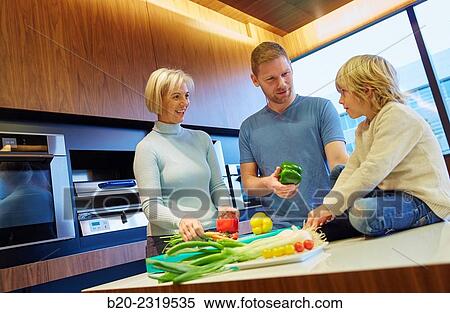 Stock Photography - Family in the kitchen. Three generations. Healthy eating. Healthy growth. Vegetables.. Fotosearch
